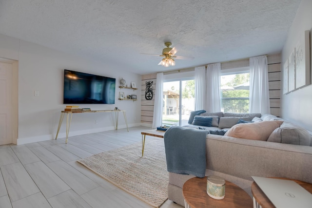 living room with ceiling fan and a textured ceiling