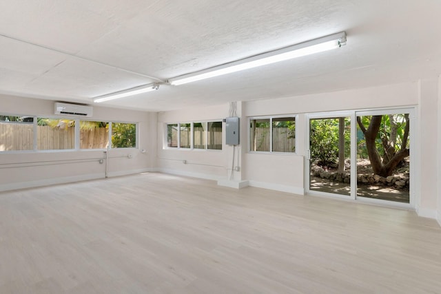 82260 Overseas Hwy, Islamorada, FL 33036 - spare room featuring an AC wall unit, wood finished floors, and electric panel