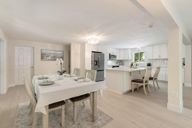 82260 Overseas Hwy, Islamorada, FL 33036 - dining room featuring light wood-style floors and baseboards
