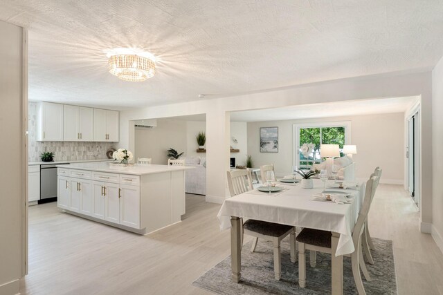 82260 Overseas Hwy, Islamorada, FL 33036 - dining space with light wood-style flooring, a textured ceiling, and a chandelier