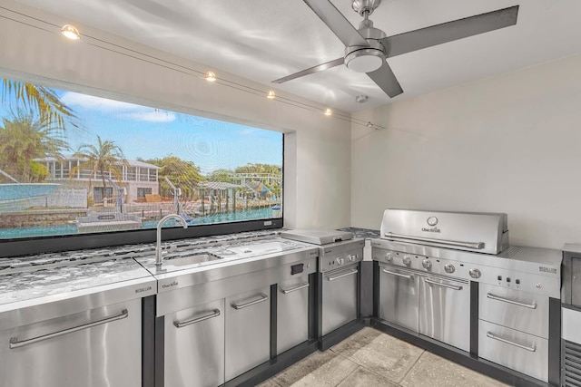 view of patio featuring ceiling fan, an outdoor kitchen, sink, and area for grilling