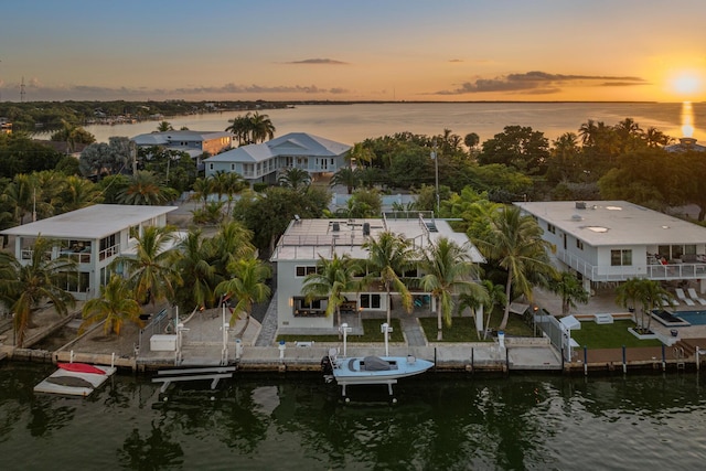 aerial view at dusk featuring a water view