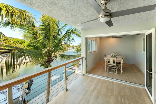 balcony with a water view and ceiling fan