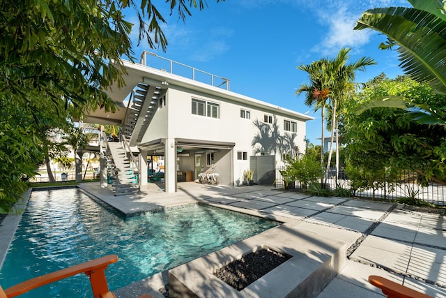 rear view of property with a fenced in pool and a patio area