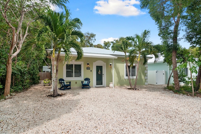 view of front of house featuring stucco siding, fence, and a gate