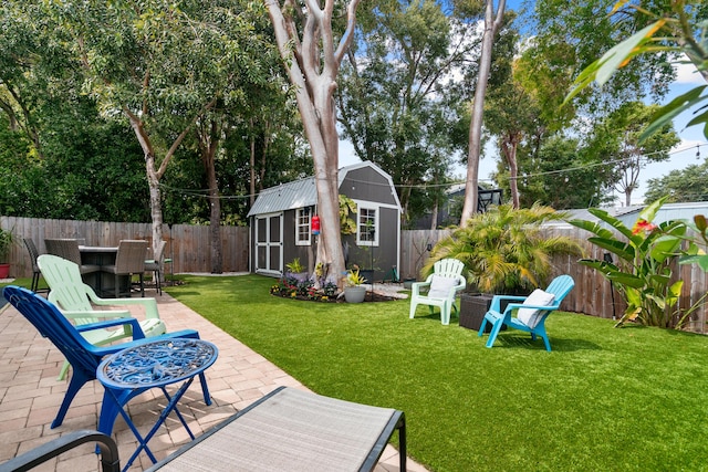 view of yard with a patio area, an outdoor structure, a storage shed, and a fenced backyard