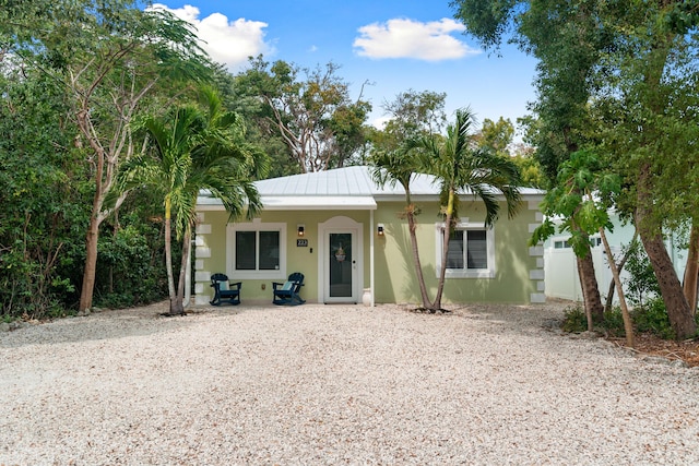 view of front of home featuring stucco siding, a porch, and metal roof