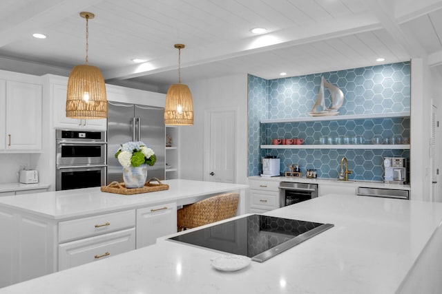 kitchen with white cabinetry, hanging light fixtures, a center island, and appliances with stainless steel finishes