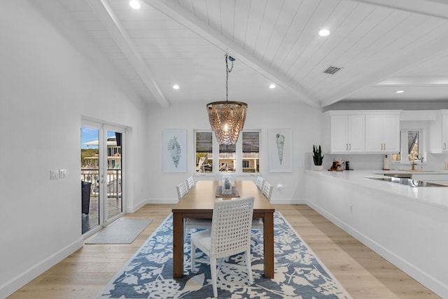 dining room featuring beamed ceiling, an inviting chandelier, and light hardwood / wood-style floors