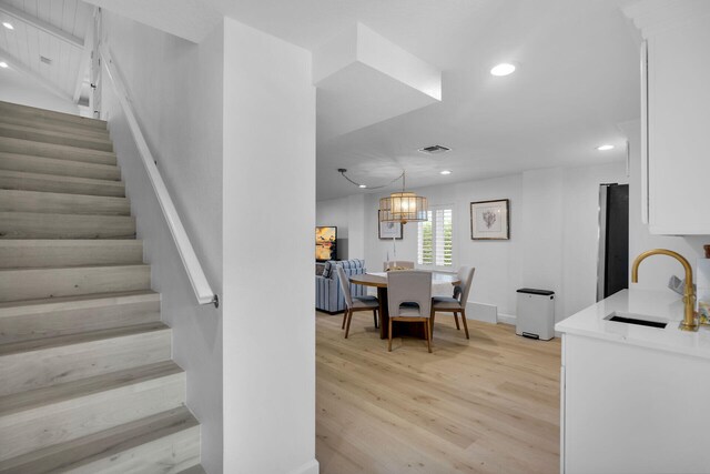 stairway with sink and hardwood / wood-style floors