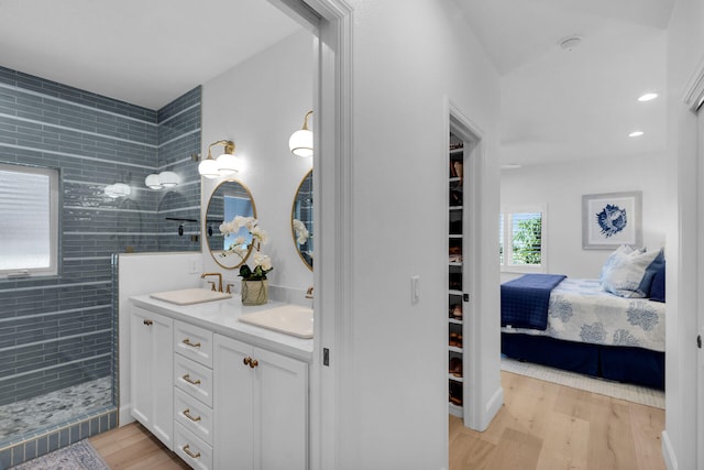 bathroom with vanity, tiled shower, and hardwood / wood-style floors