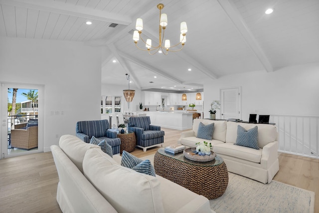 living room with lofted ceiling with beams, light hardwood / wood-style flooring, and a notable chandelier