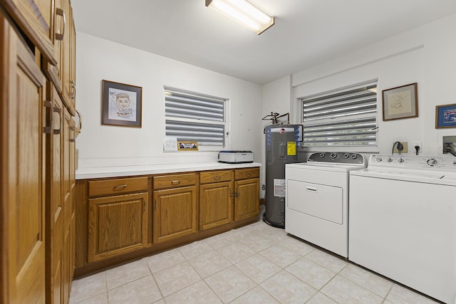 washroom with electric water heater, cabinets, washing machine and dryer, and light tile patterned flooring