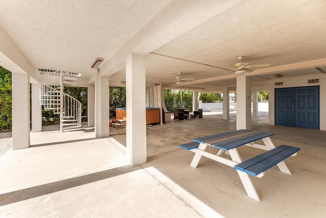 view of patio with ceiling fan and a hot tub