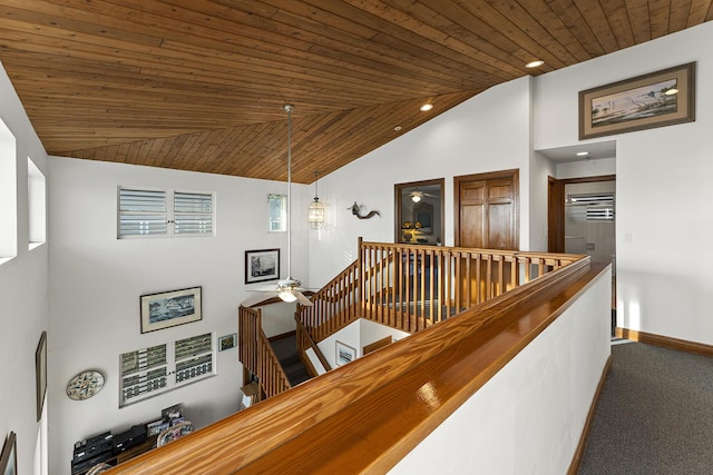 corridor featuring carpet floors, vaulted ceiling, and wooden ceiling