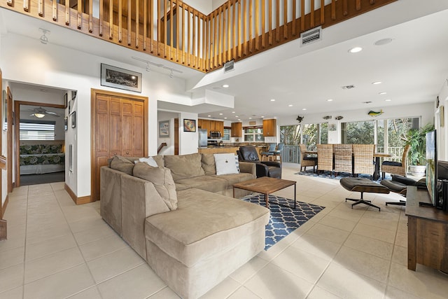 tiled living room with a towering ceiling