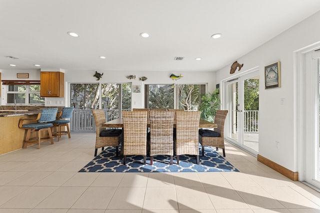 dining space with sink, french doors, and light tile patterned floors