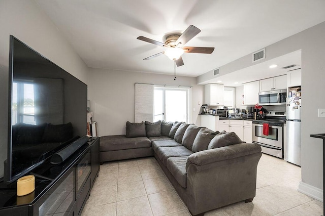 tiled living room with ceiling fan