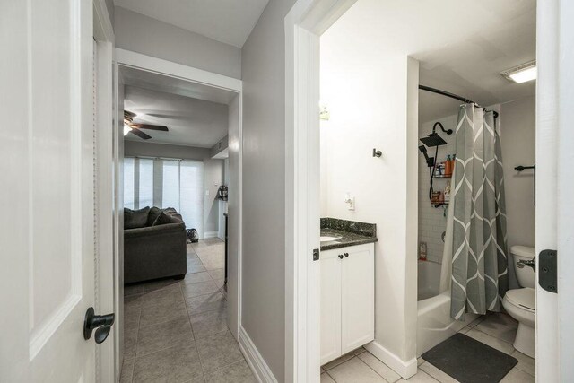 full bathroom with vanity, ceiling fan, toilet, shower / bathtub combination with curtain, and tile patterned floors