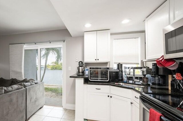 kitchen featuring white cabinetry, sink, and light tile patterned floors