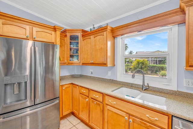 kitchen with lofted ceiling, sink, light tile patterned floors, appliances with stainless steel finishes, and light stone counters