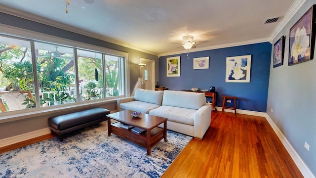 living room with hardwood / wood-style flooring, ornamental molding, and ceiling fan