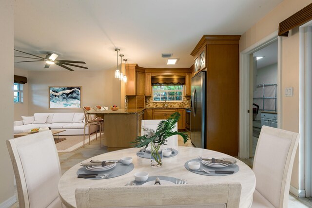 dining area with ceiling fan and sink