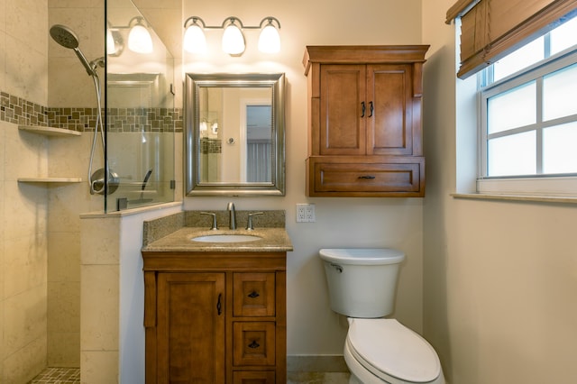 bathroom with vanity, a tile shower, and toilet