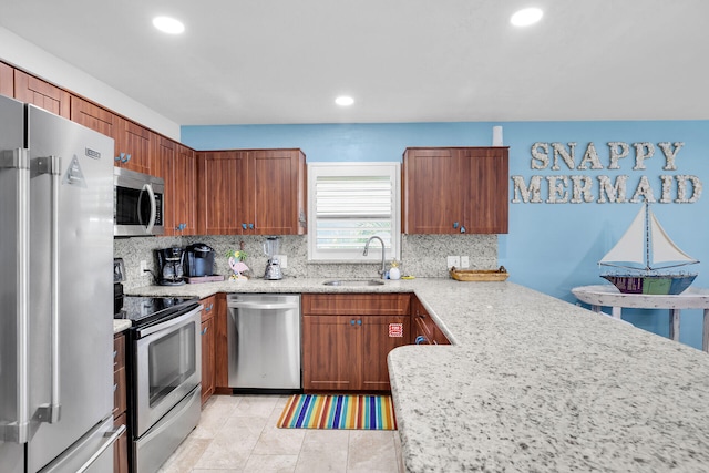 kitchen featuring tasteful backsplash, sink, kitchen peninsula, stainless steel appliances, and light stone countertops