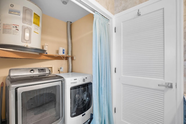 washroom with water heater and separate washer and dryer