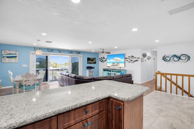 kitchen with decorative light fixtures and light stone countertops