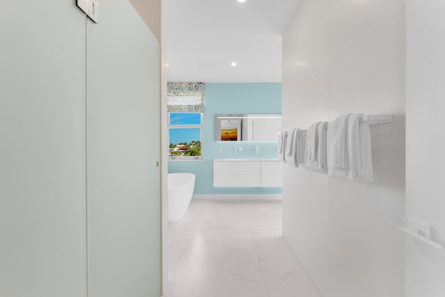 bathroom with a tub to relax in and vanity