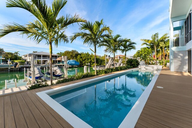 view of swimming pool featuring a water view and a boat dock