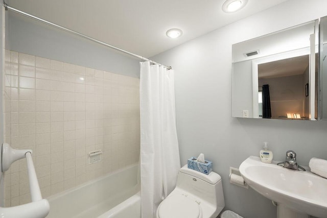 full bathroom featuring shower / tub combo with curtain, sink, and toilet