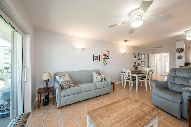 tiled living room with ceiling fan and a wealth of natural light