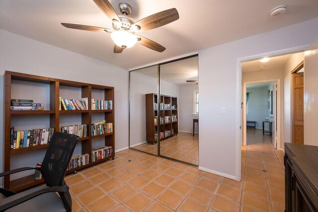 tiled home office featuring ceiling fan