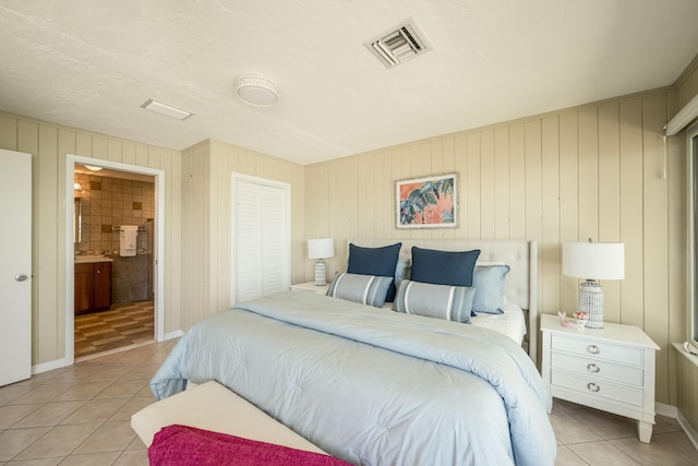 tiled bedroom featuring connected bathroom