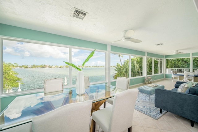 sunroom with a water view, a healthy amount of sunlight, and ceiling fan