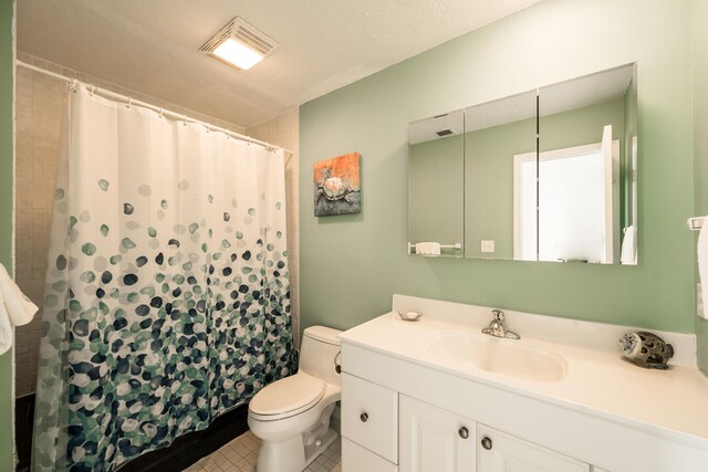 bathroom featuring tile patterned flooring, vanity, a shower with shower curtain, and toilet