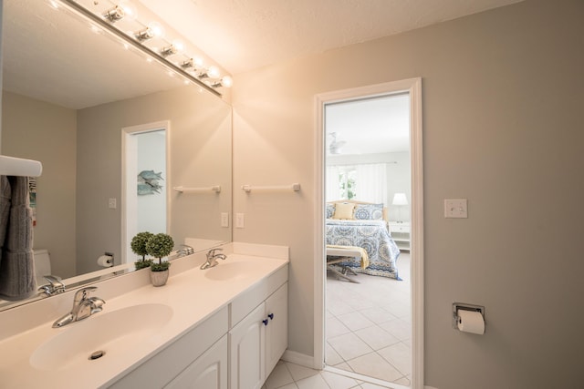 bathroom with tile patterned flooring, vanity, and toilet