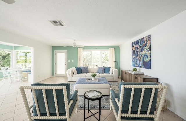 tiled living room with ceiling fan and a textured ceiling