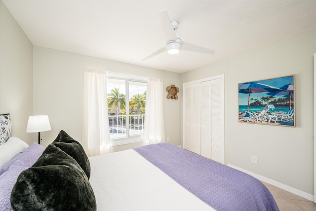 tiled bedroom with ceiling fan and a closet