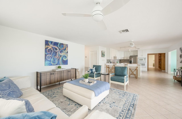 living room featuring light tile patterned floors and ceiling fan