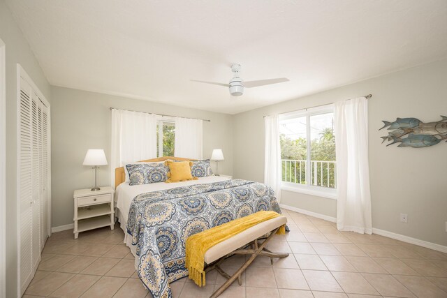 bedroom with multiple windows, light tile patterned floors, and ceiling fan