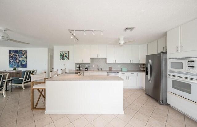 kitchen featuring ceiling fan, white cabinets, white appliances, and decorative backsplash