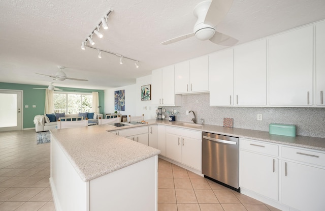 kitchen with white cabinetry, stainless steel dishwasher, light tile patterned flooring, and sink