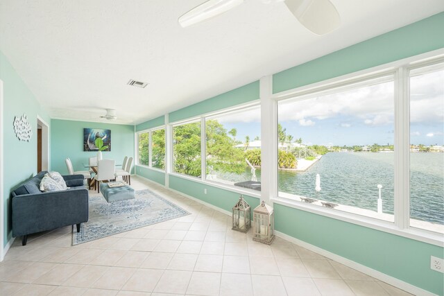 sunroom with a water view and ceiling fan