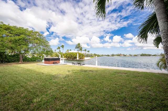 view of yard featuring a hot tub and a water view