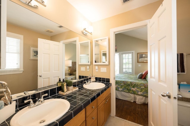 bathroom featuring vanity, lofted ceiling, and toilet