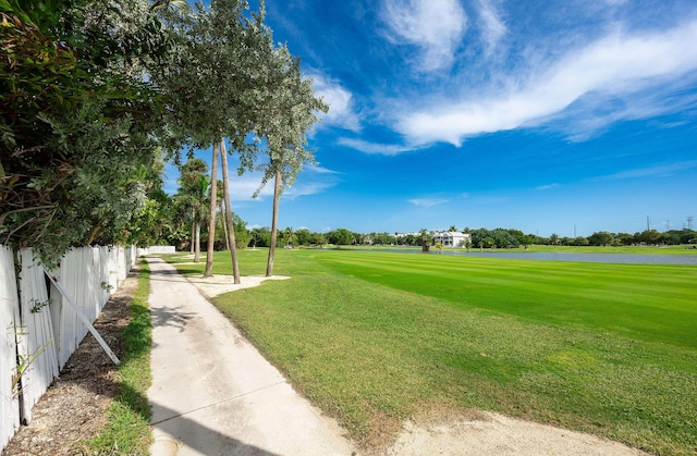 surrounding community featuring a lawn and a water view